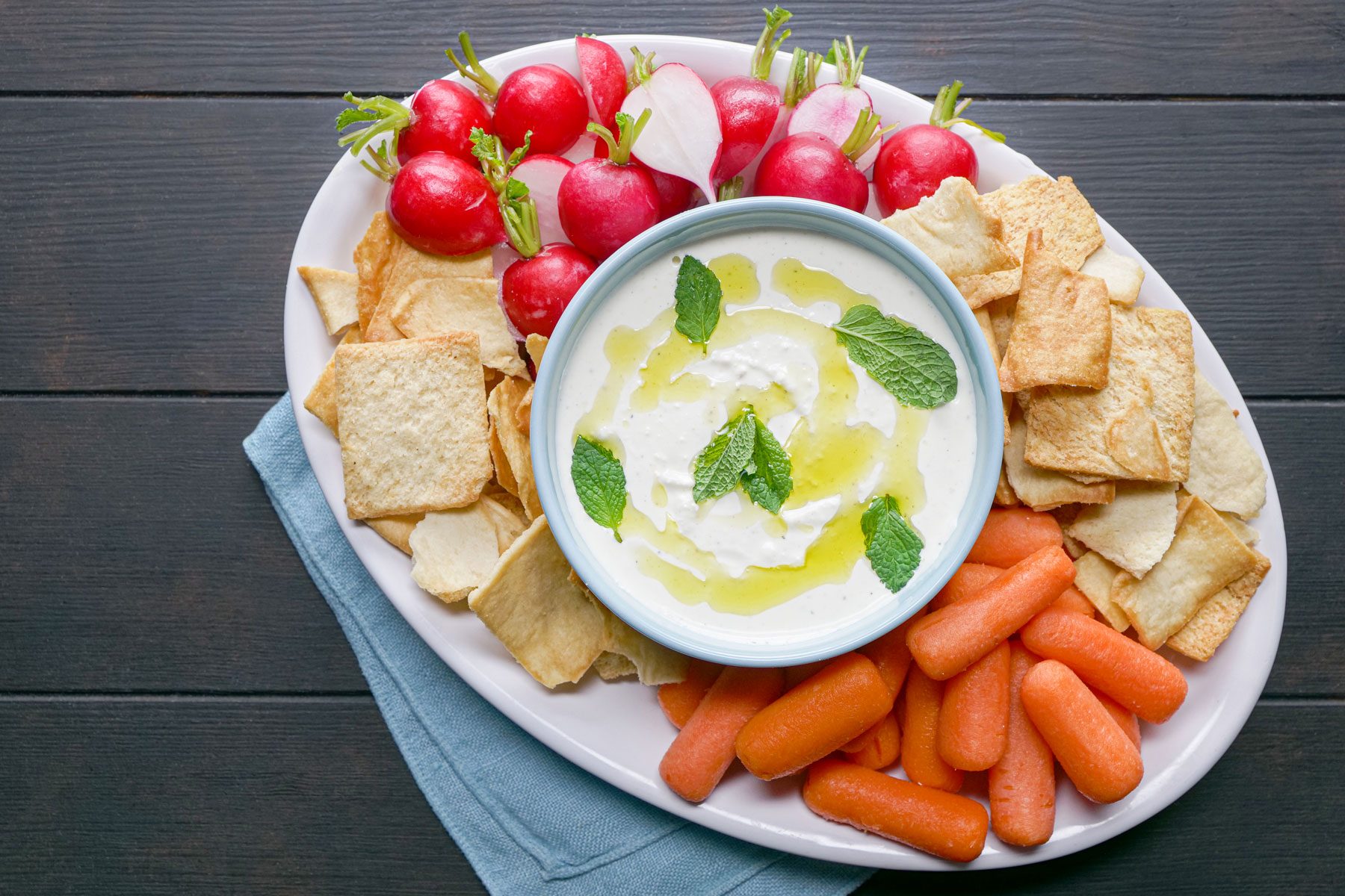 Whipped Feta Dip with other vegetables and snacks in served in a small plate