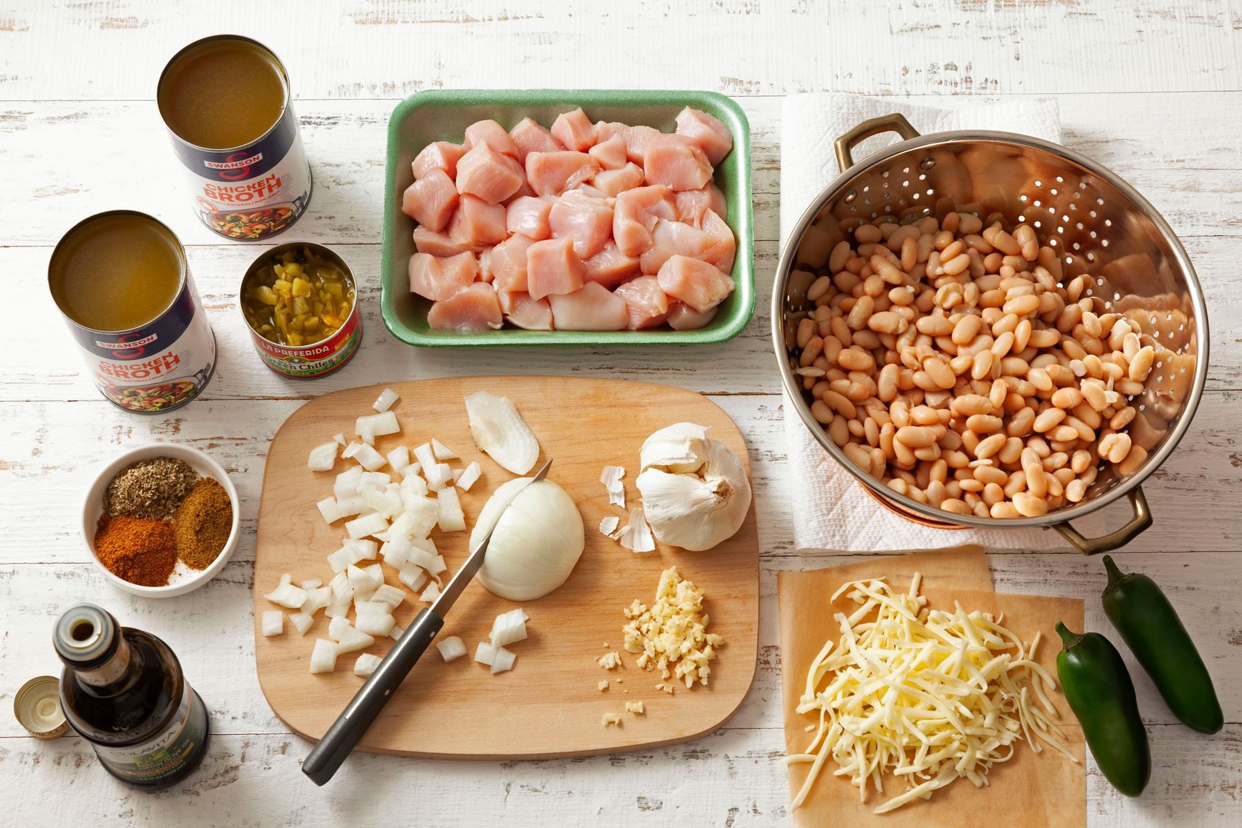 Ingredients to make White Chicken Chili place on a wooden surface