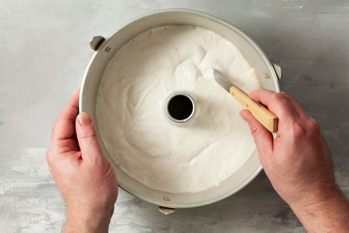 Cutting through the cream mixture with a knife 