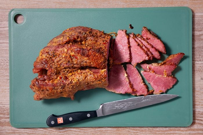 Baked Corned Beef with a knife on cutting board
