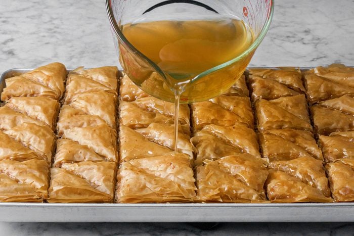 Pouring the syrup over Baklava 