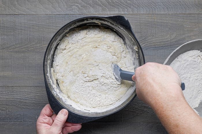 Mixing flour and other ingredients in a large bowl with spatula