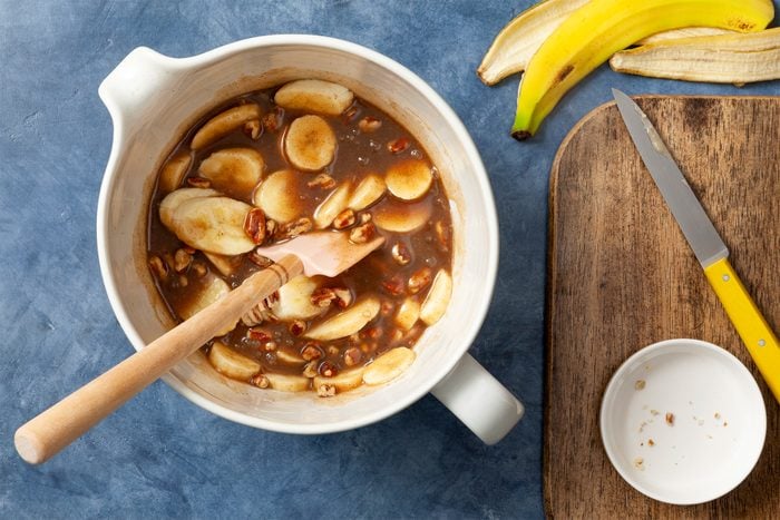 A bowl of milk,pecans,bananas and nuts