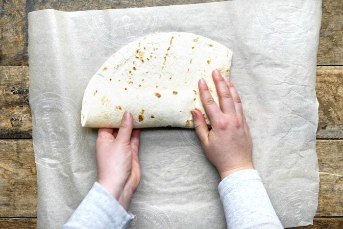 hands folding tortilla