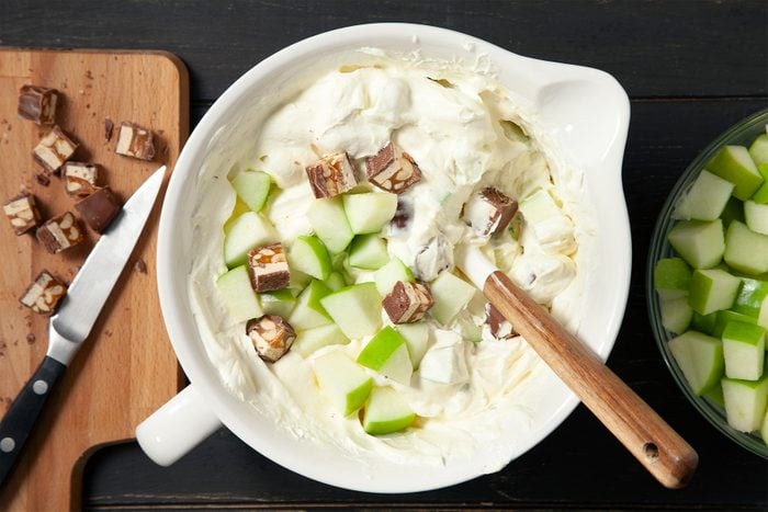 A bowl of milk and Pudding Mixture with apple in it