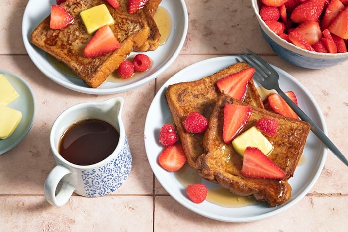Cinnamon French served with butter and strawberries on a wooden table