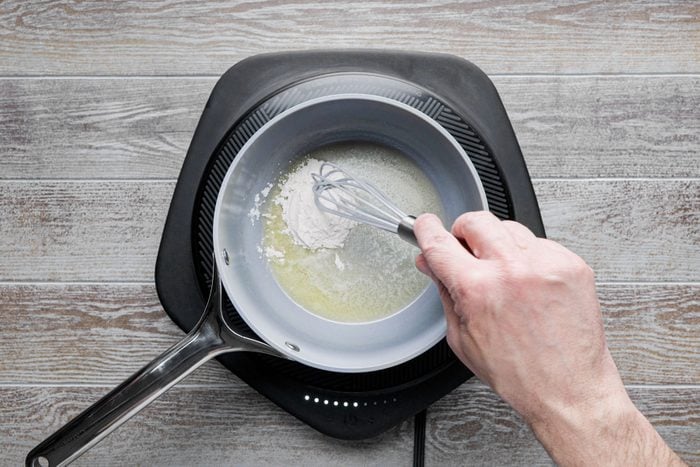 Whisking butter and flour in a small saucepan
