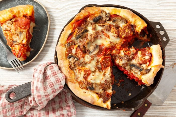 Baked Deep Dish Pizza on skillet and a slice on plate