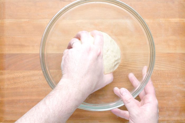Putting dough in a glass bowl to rest 