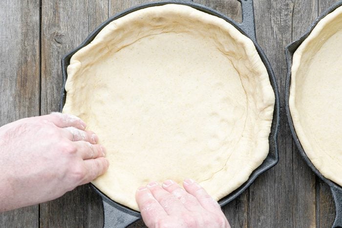 Pressing the dough on the edges of the skillet