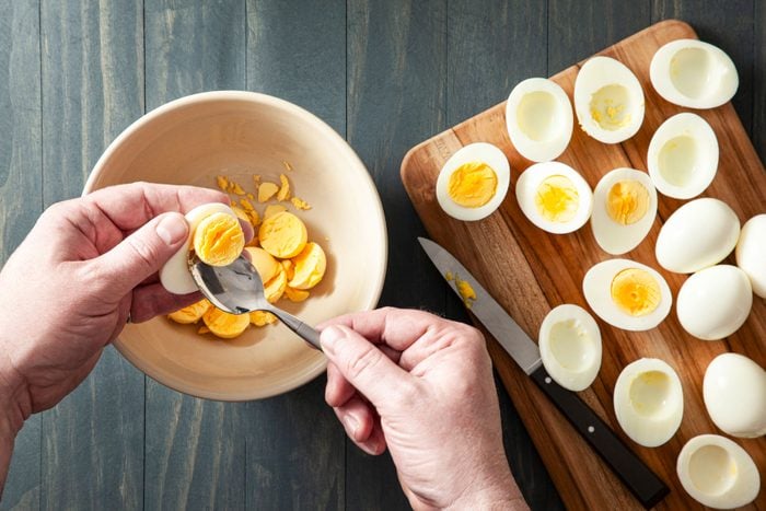 Removing the yolk for the hard boiled eggs through a spoon