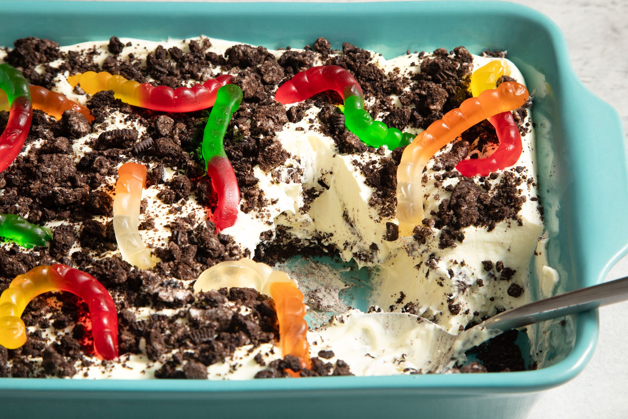 Dirt Dessert Topped With Gummy Worms in a Baking Dish on Grey Background
