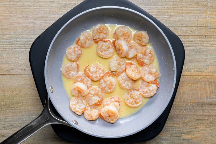 Cooking shrimp with lemon juice in a large skillet