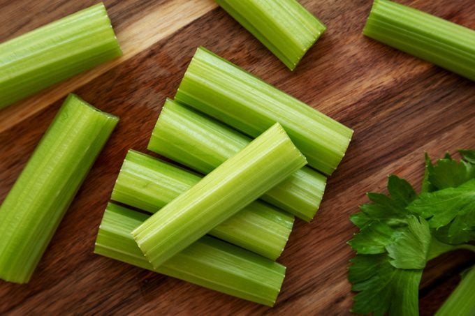 Raw Organic Celery on a wooden board, top view. Flat lay, overhead, from above. Close-up.