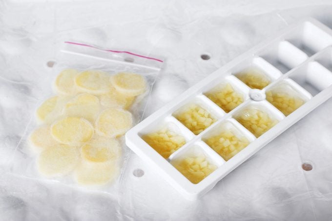 sliced frozen gigner i na plastic bag and chopped frozen ginger in an ice cube tray