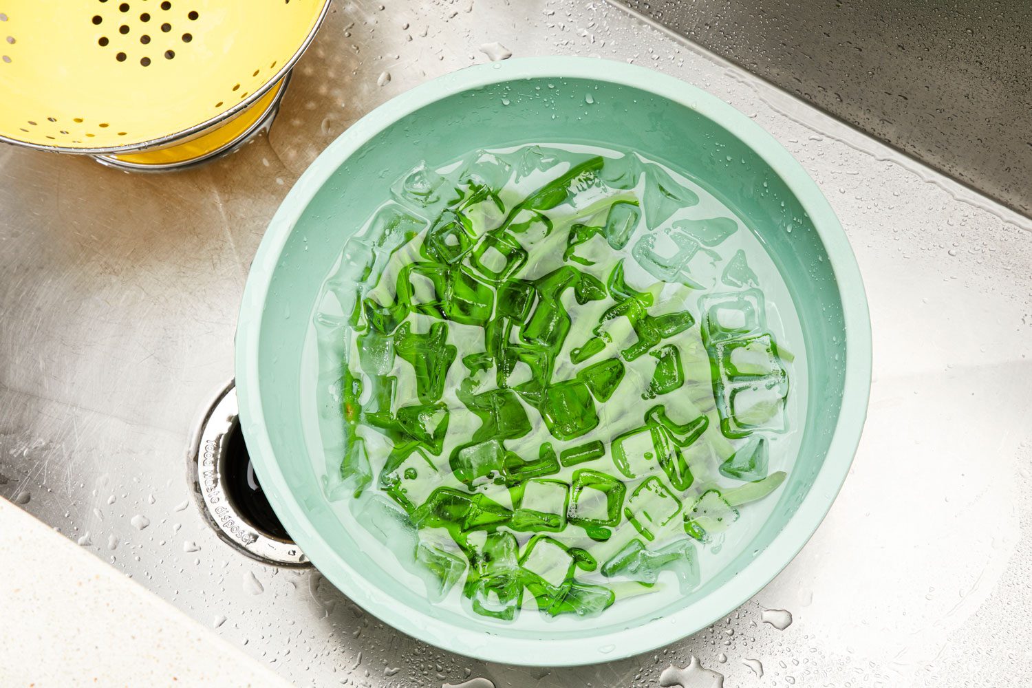 Green beans in an ice bath after boiling.