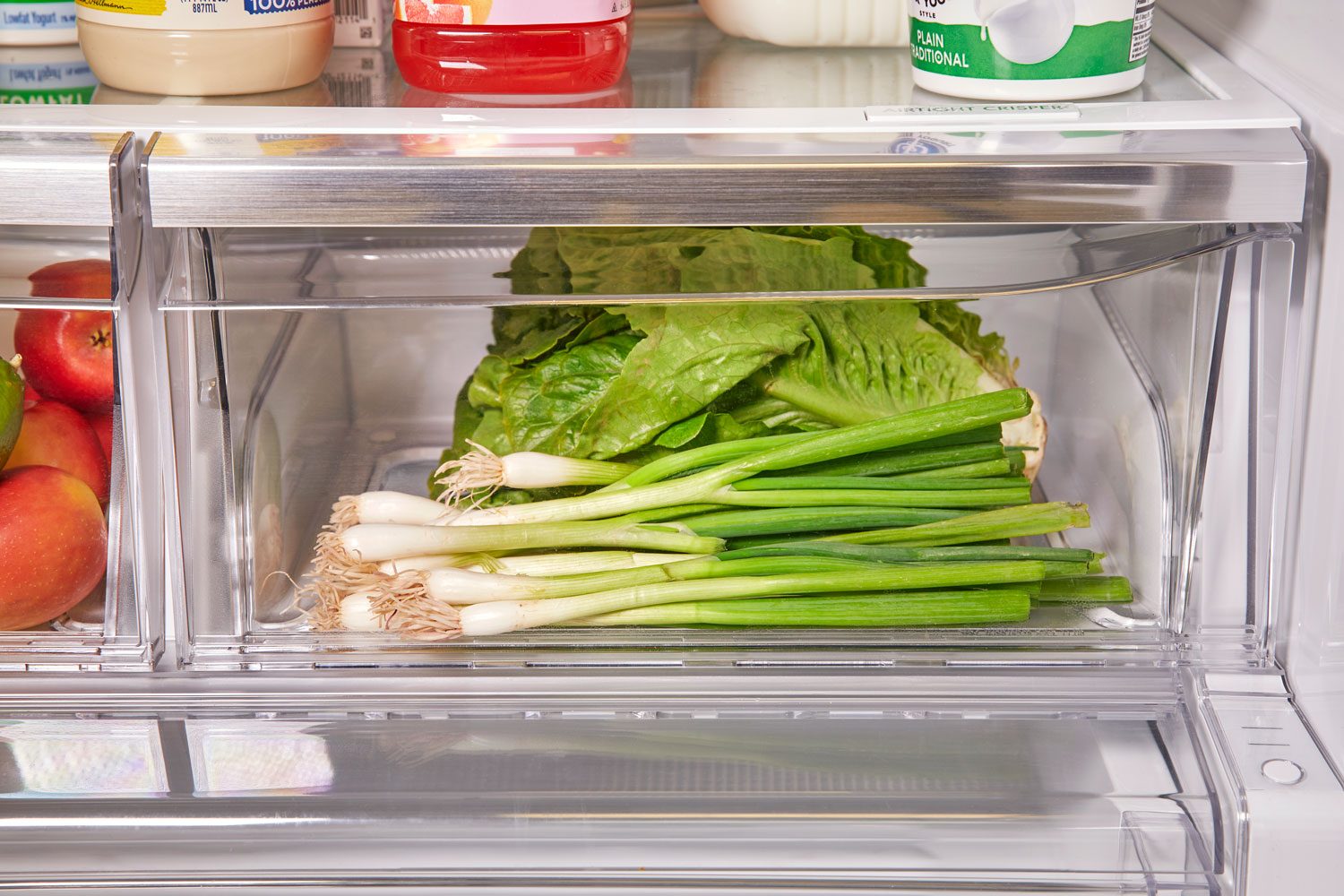 green onions in the crisper drawer of a refrigerator