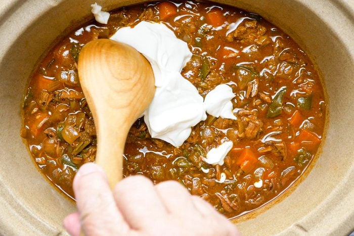Stirring the sour cream on Hungarian-Goulash in a slow cooker