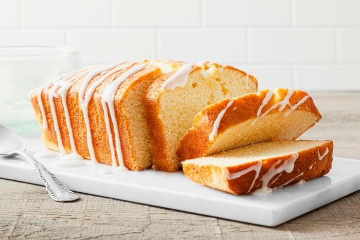 Lemon Bread with a Spoon on a Marble Chopping Board on Wooden Surface