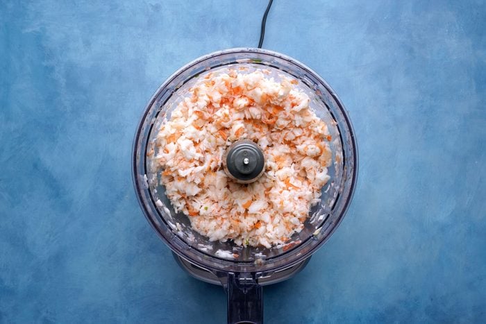 finely chopped Shrimp inside a blender on a blue countertop