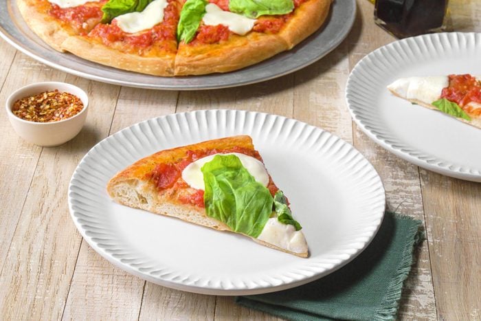 A slice of margherita pizza on a plate