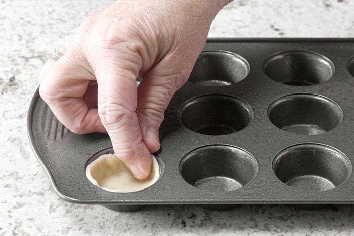 Pressing the circle dough in muffin tray