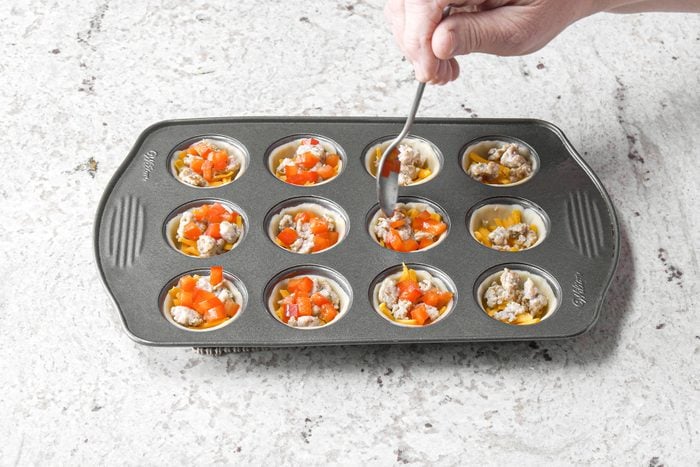 Adding toppings to dough in baking tray