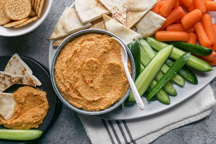 Humus served with pita bread, carrots, cucumbers and crackers