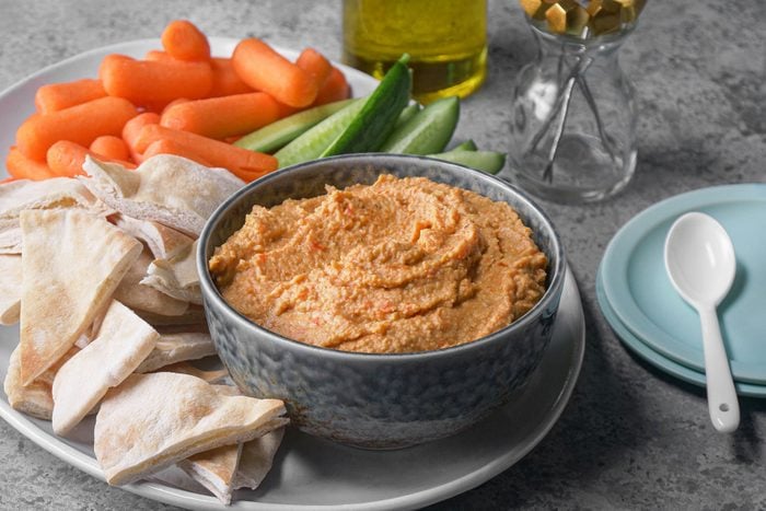 Humus served with pita bread, carrots, cucumbers and crackers