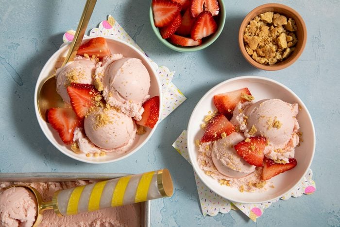 Strawberry Cheesecake Ice Cream served in small white plates with strawberries