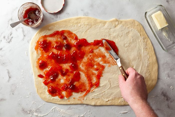 Spreading Strawberry Fillings on dough with butter knife