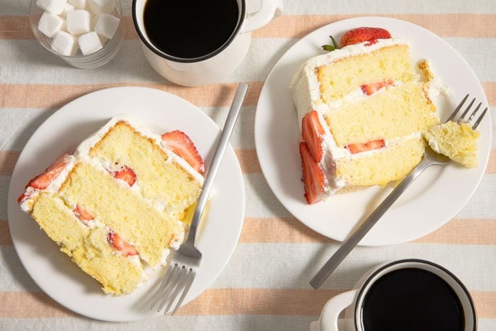 Slices Strawberry Cream Cake served on small plates with coffee