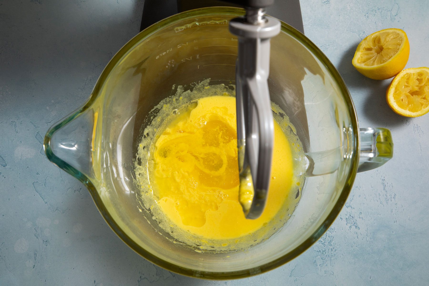 Mixing lemon juice and egg yolk in a blender on a marble countertop