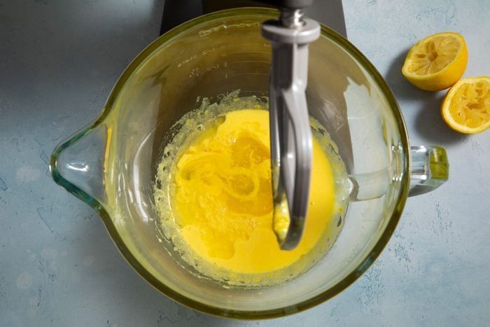Mixing lemon juice and egg yolk in a blender on a marble countertop