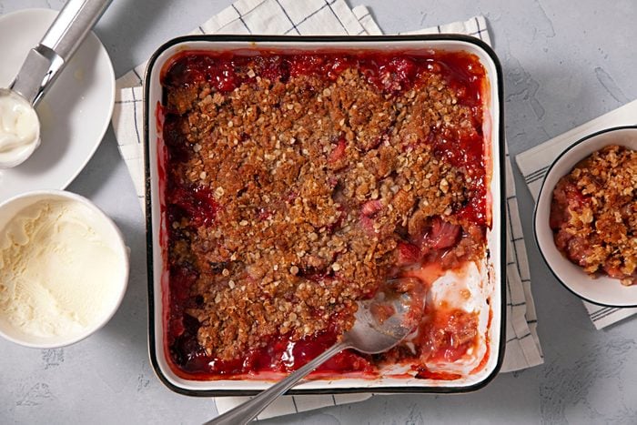 Strawberry Rhubarb Crisp served in a baking tray with vanilla ice cream