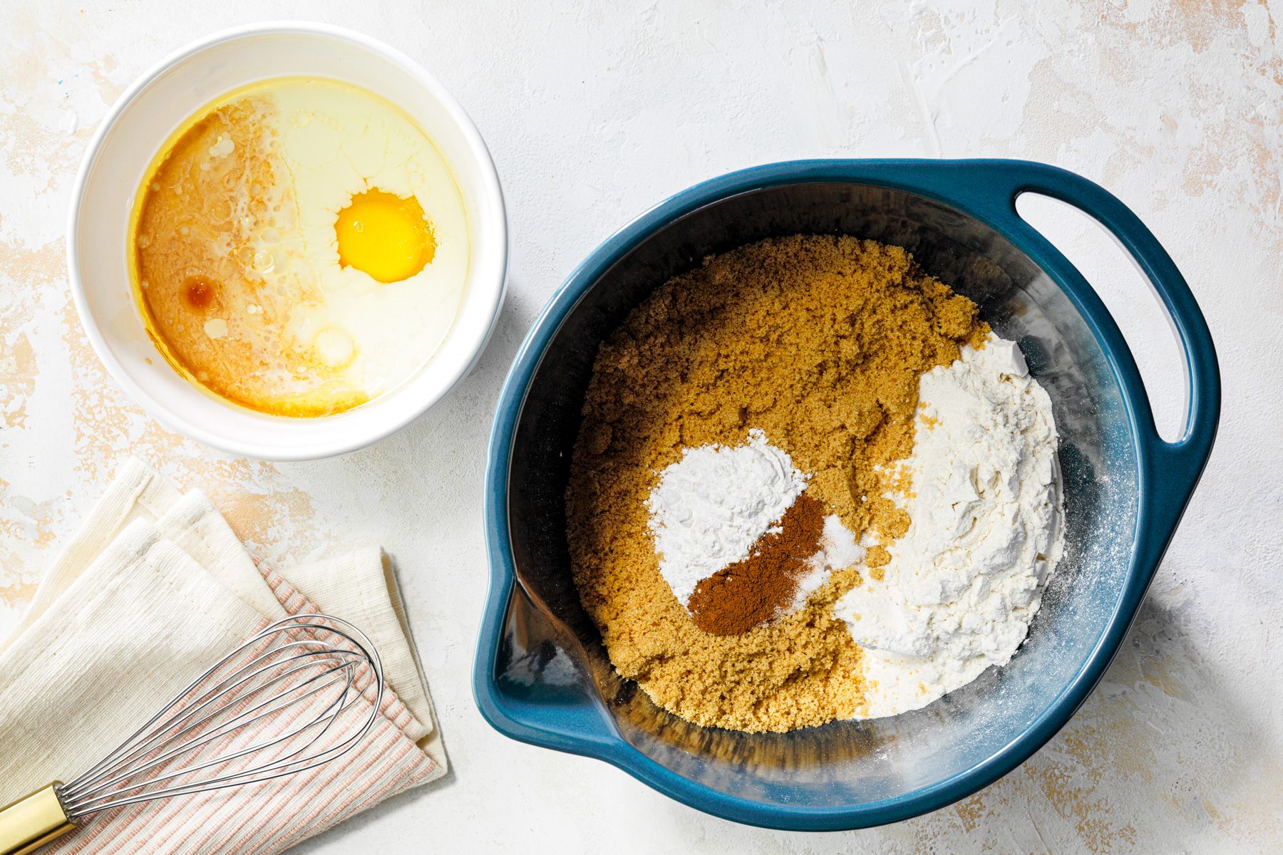 Two separate bowls with eggs and dry ingredients