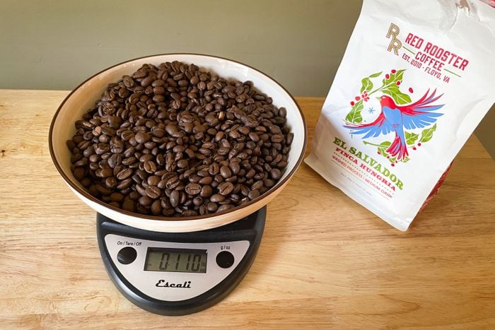 Coffee beans on a weighing machine on a wooden surface