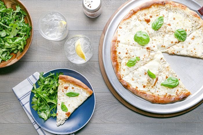 White Pizza served on plate with drinks on side