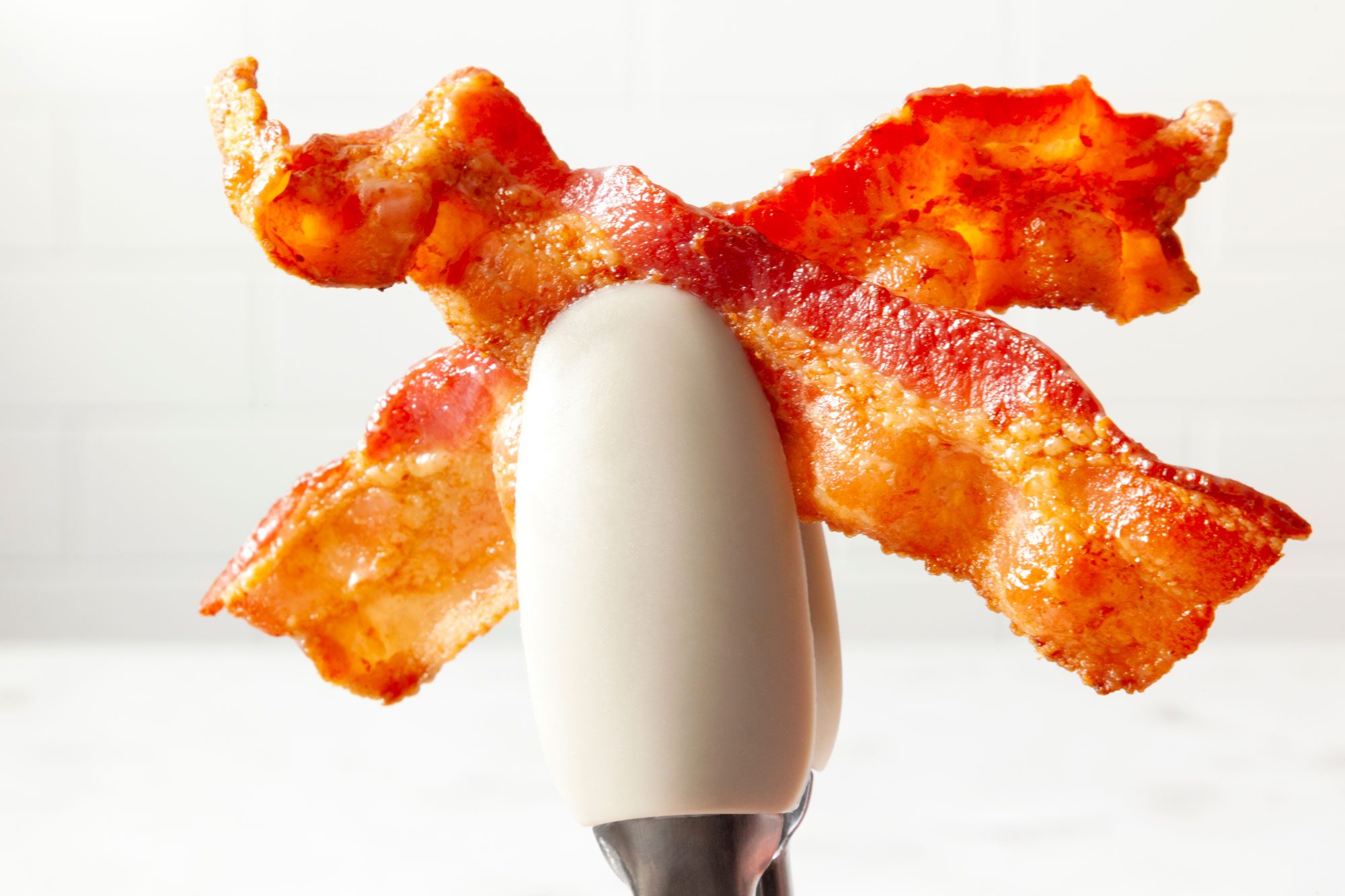 Holding the Air Fryer Bacon with tong
