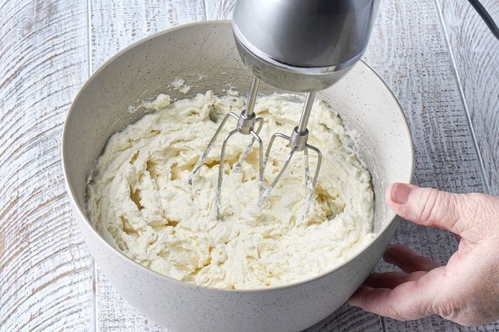 Mixing cream cheese in large bowl with stand mixer
