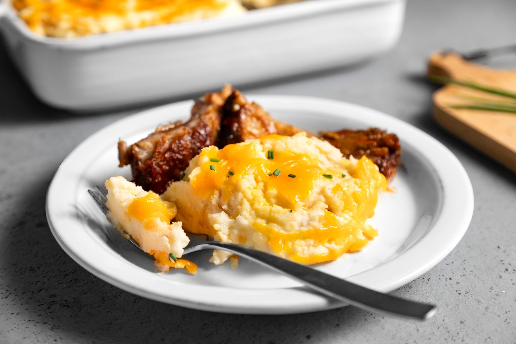 Baked cheesy mashed potatoes topped with savory meat and melted cheese