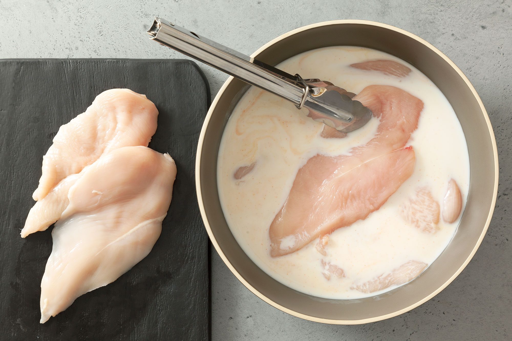 Coating Chicken Breasts in a bowl of Buttermilk and Hot Sauce