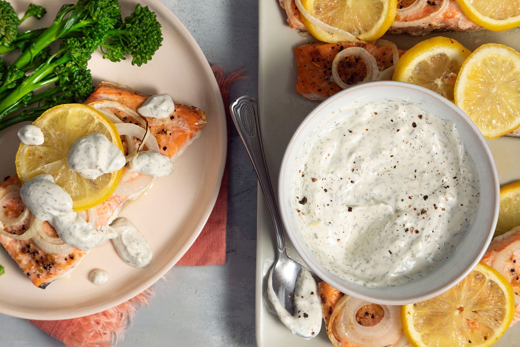 A plate of food with a bowl of Dill Sauce for Salmon and lemon slices