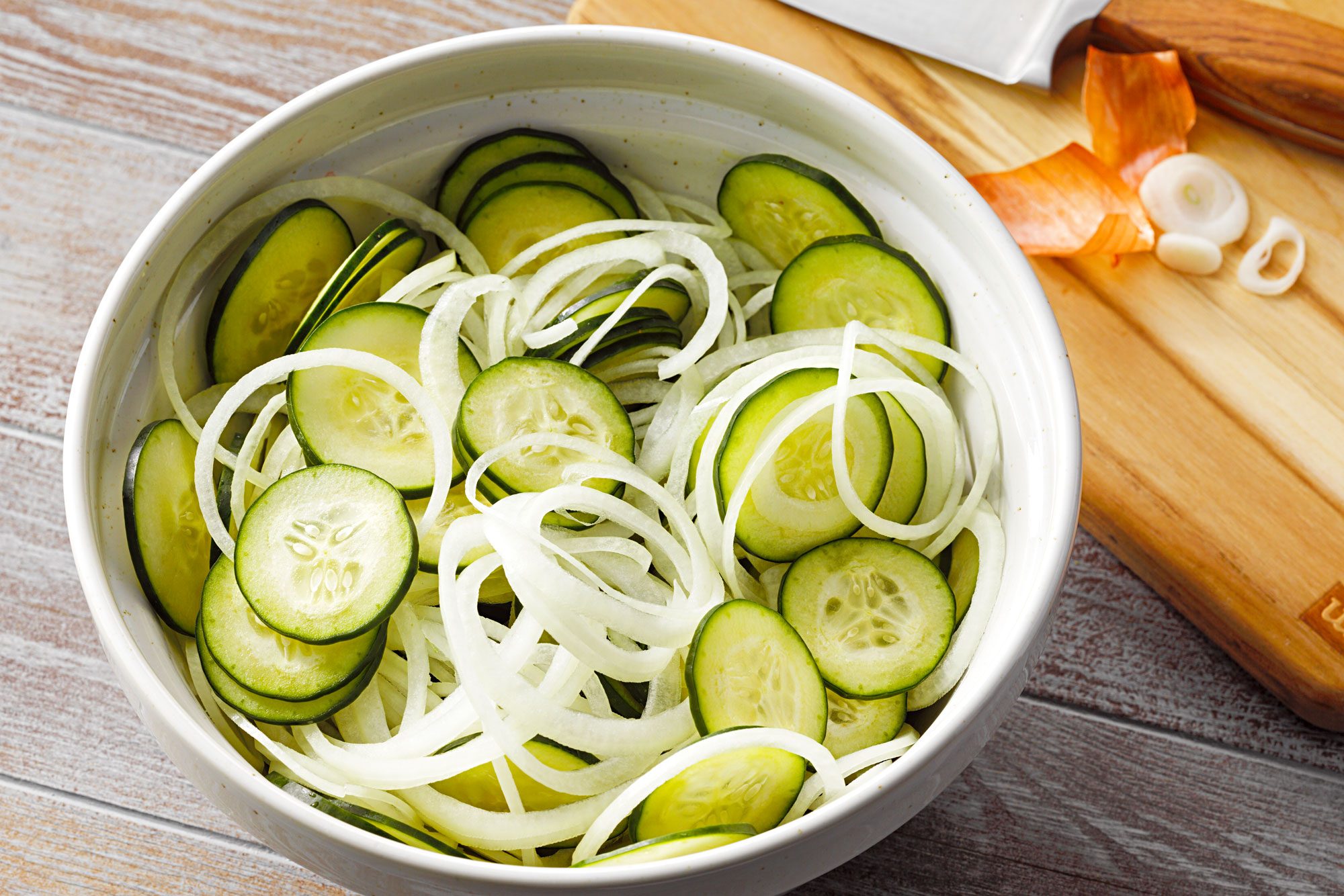 high angle shot of cucumbers and onions in a large bowl
