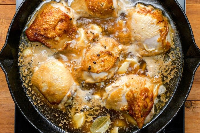 Cooking chicken in broth in skillet