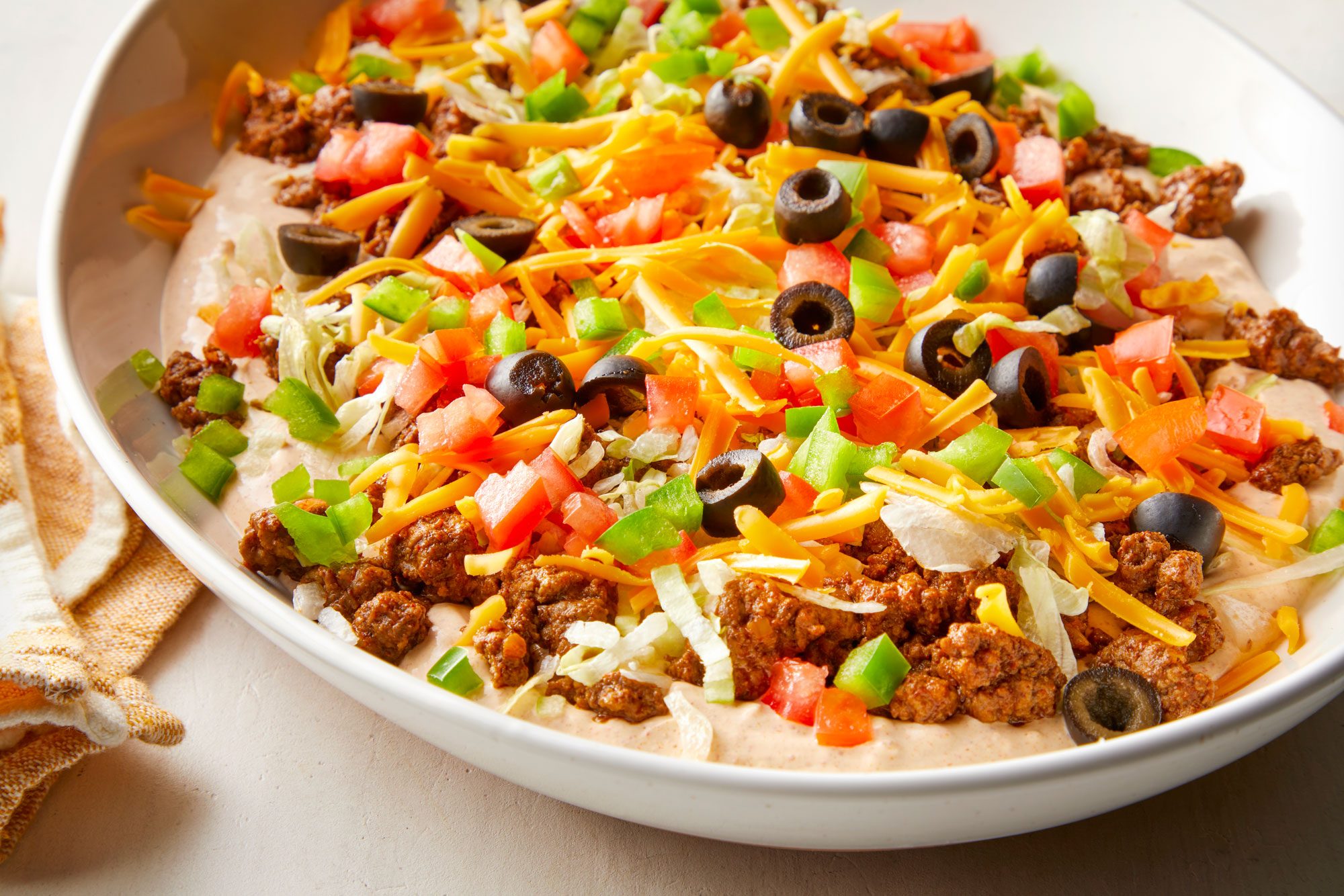 wide shot of ground beef taco dip in a large serving dish