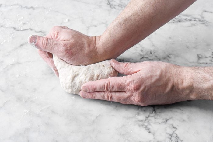 Knead the dough on a marble countertop 