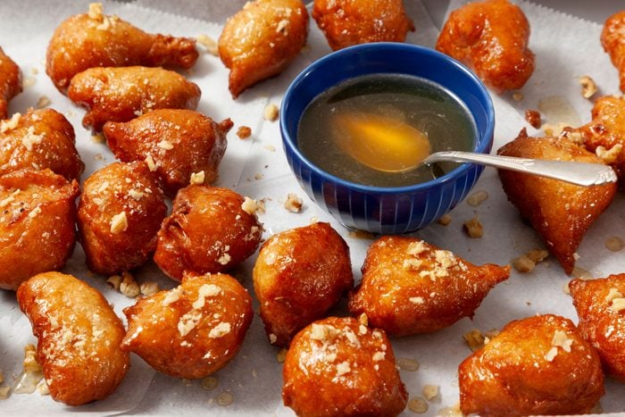 Garnished Loukoumades (Greek Doughnuts) with crushed Nuts and honey