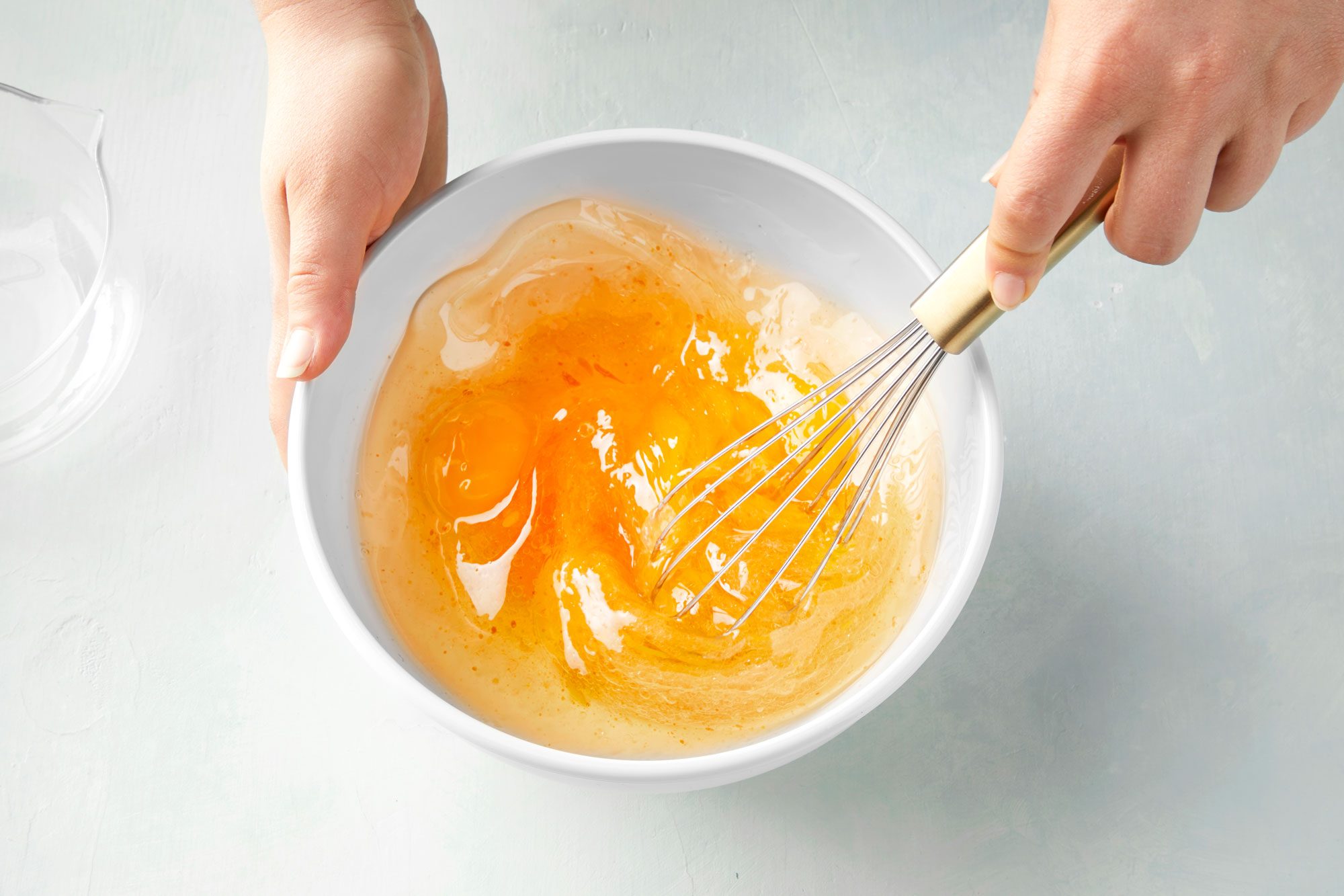 overhead shot of eggs whisking in a large bowl