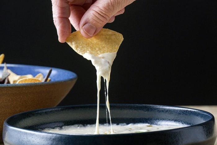 Dipping nacho in Queso Dip